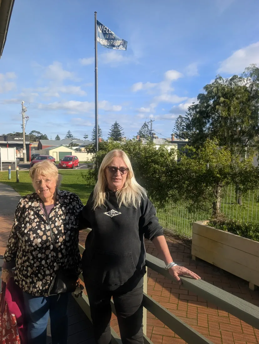 Two Neighbourhood Centre members on the front verandah at Mitchell House